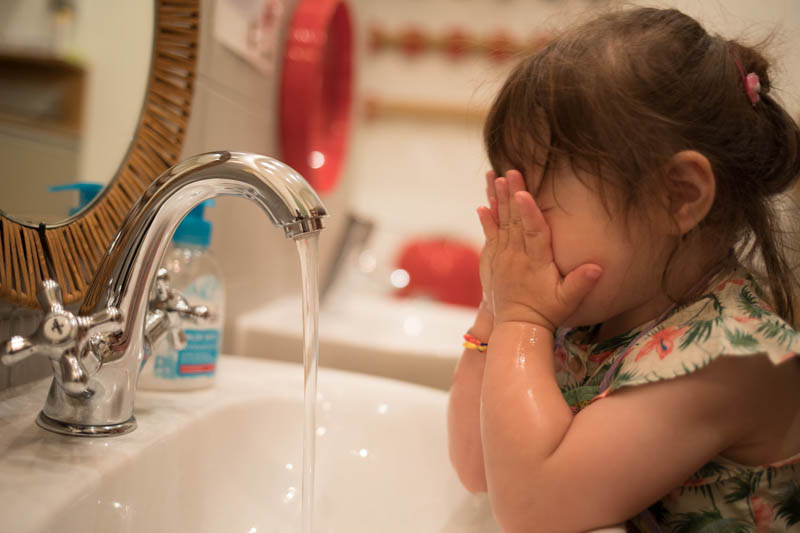 Kind wäscht sich Gesicht